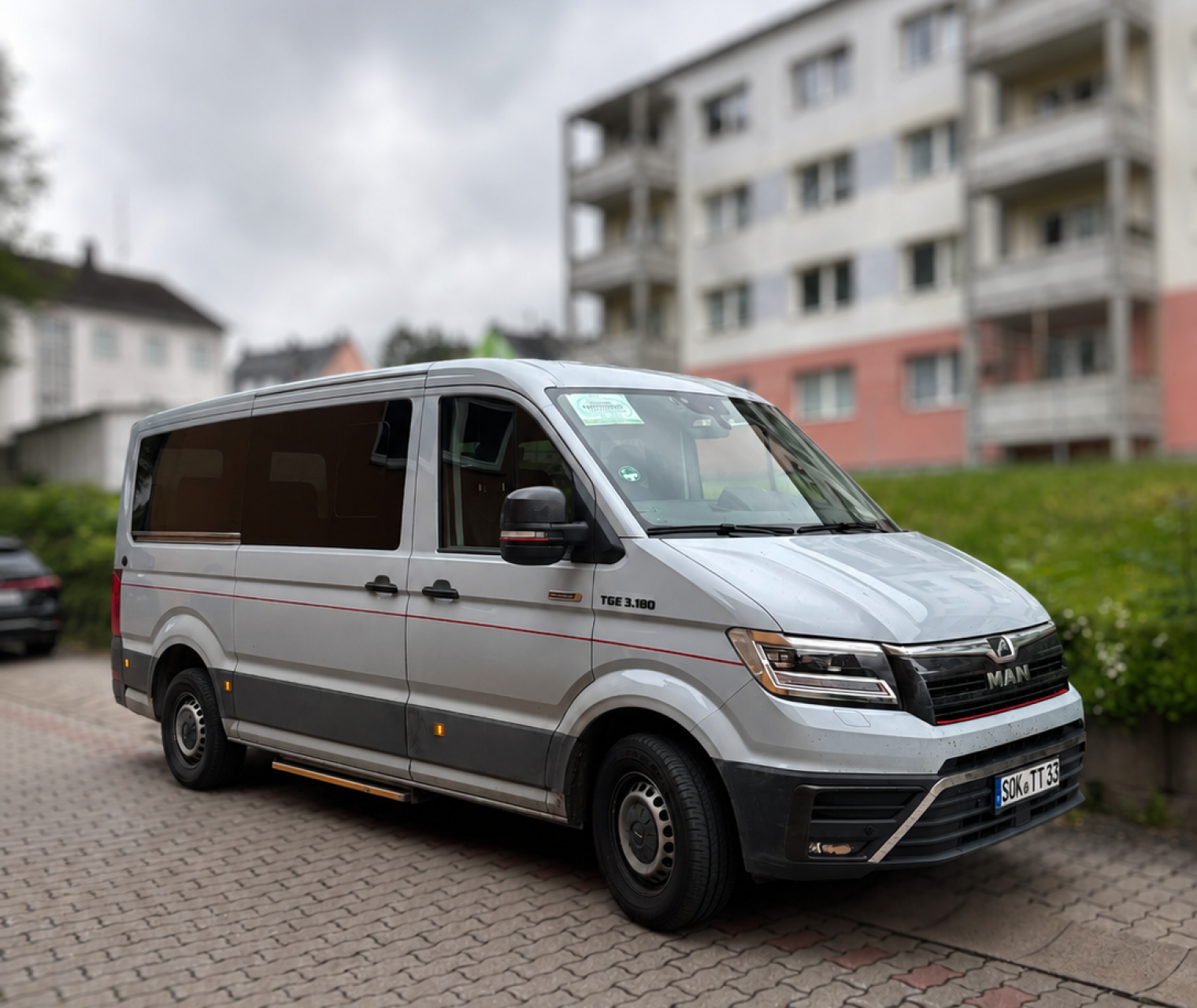 Silberner Van vor urbaner Kulisse